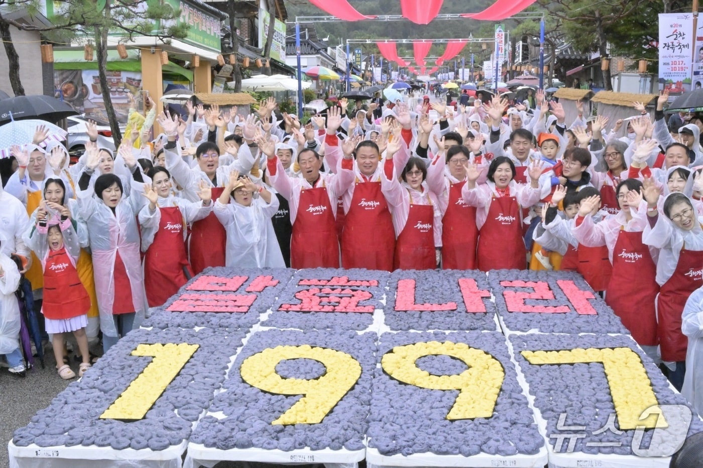 18일 전북 순창군 전통고추장민속마을 야외마당에서 순창장류축제 대표 프로그램 '발효나라 1997' 프로그램이 진행된 가운데 참여자들이 기념 촬영을 하고 있다. 이 프로그램은 민속마을이 조성된 지난 1997년의 의미를 담아 참가자들이 간장·고춧가루·메줏가루를 상징하는 검은색·빨간색·노란색 가래떡으로 글씨를 만드는 퍼포먼스다.(순창군 제공. 재판매 및 DB금지)/뉴스1