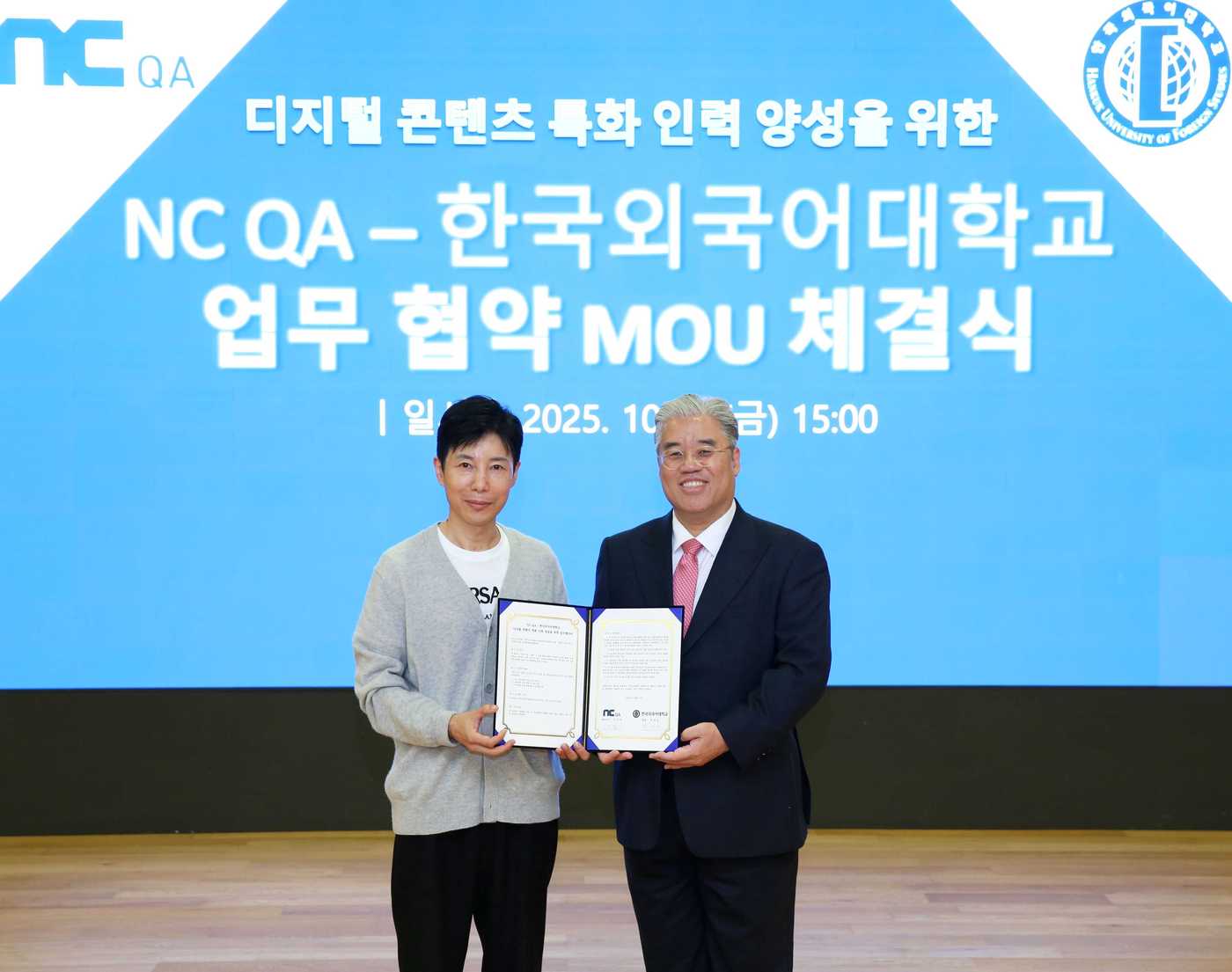 NC QA가 한국외국어대학교와 디지털 콘텐츠 특화 인력 양성을 위한 업무협약(MOU)을 체결했다. 김진섭 NC QA 대표(왼쪽)와 임대근 한국외대 교수가 MOU 증서를 들어 보이고 있다.(엔씨소프트 제공. 재판매 및 DB금지)2025.10.20/뉴스1