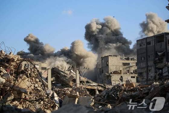 19일&#40;현지시간&#41; 이스라엘의 공습으로 가자지구 중부의 팔레스타인 난민 캠프인 부레이지에서 건물이 무너져 연기가 치솟고 있다. 2025.10.19 ⓒ AFP=뉴스1