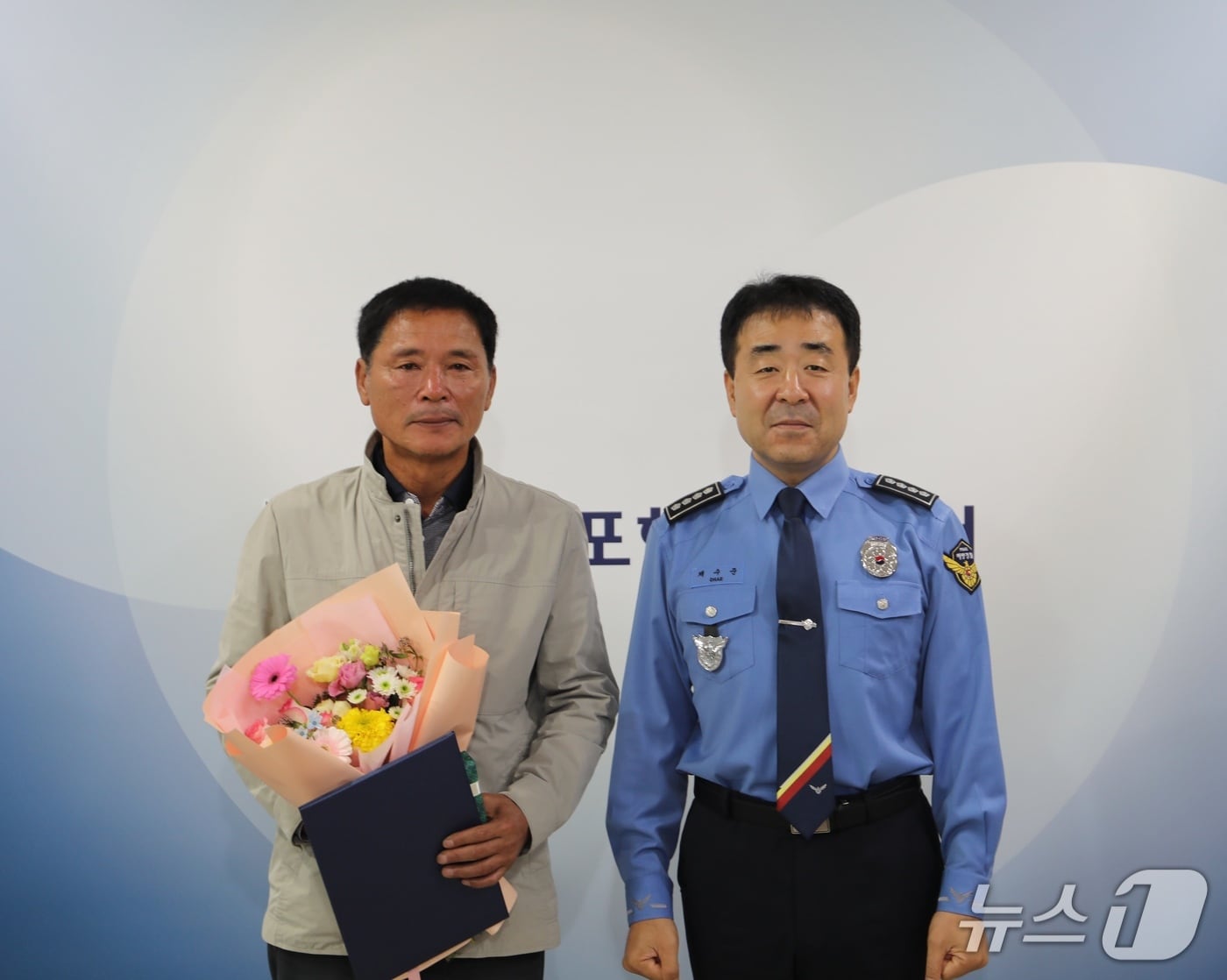 채수준 목포해양경찰서장(오른쪽)이 27일 전복된 어선에서 생명을 구한 황동연 선장(63)에게 표창장을 수여한 뒤 기념사진을 찍고 있다. (목포해경 제공. 재판매 및 DB 금지)