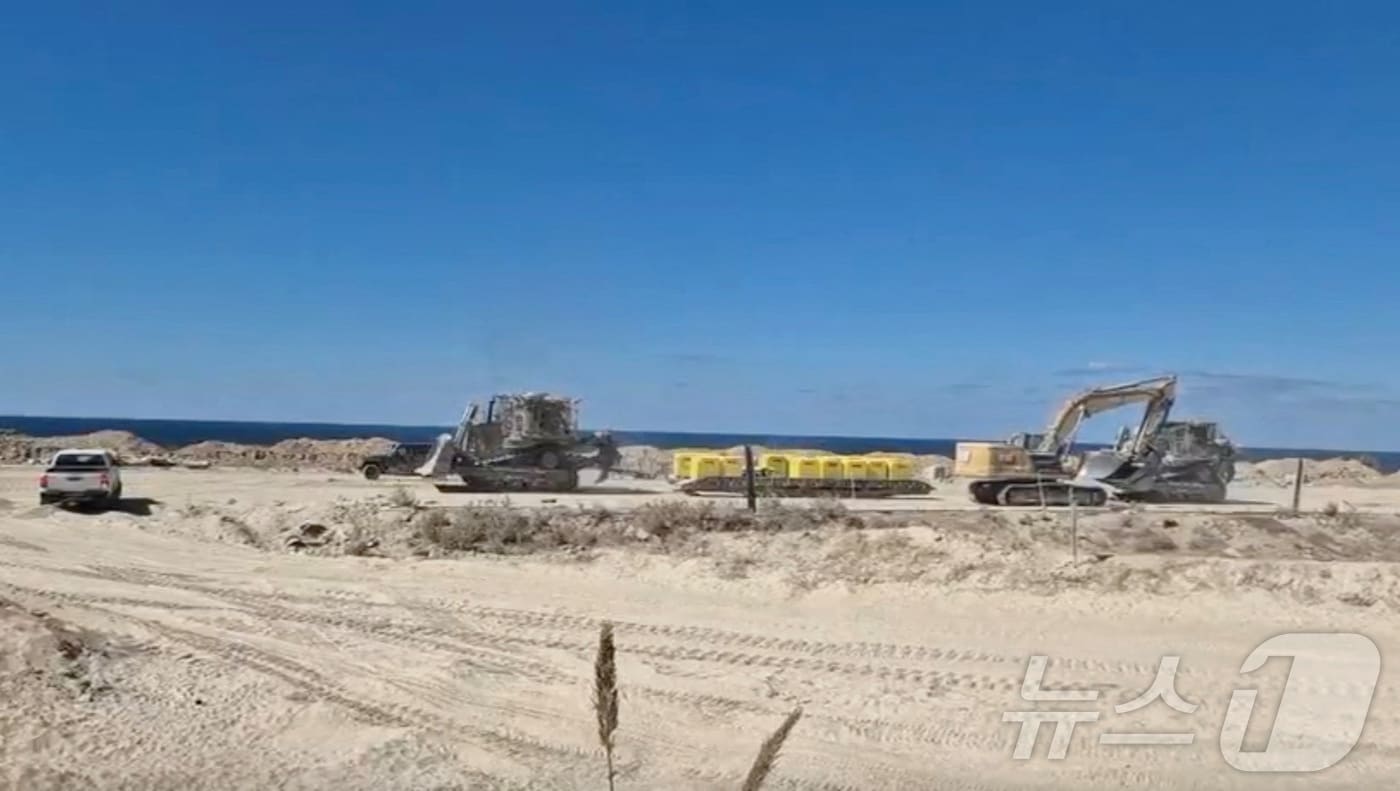 한 차량이 20일 가자지구에서 이스라엘군의 임시 후퇴선을 표시하는 노란색 콘크리트 표지를 나르고 있다. ⓒ 로이터=뉴스1 ⓒ News1 강민경 기자