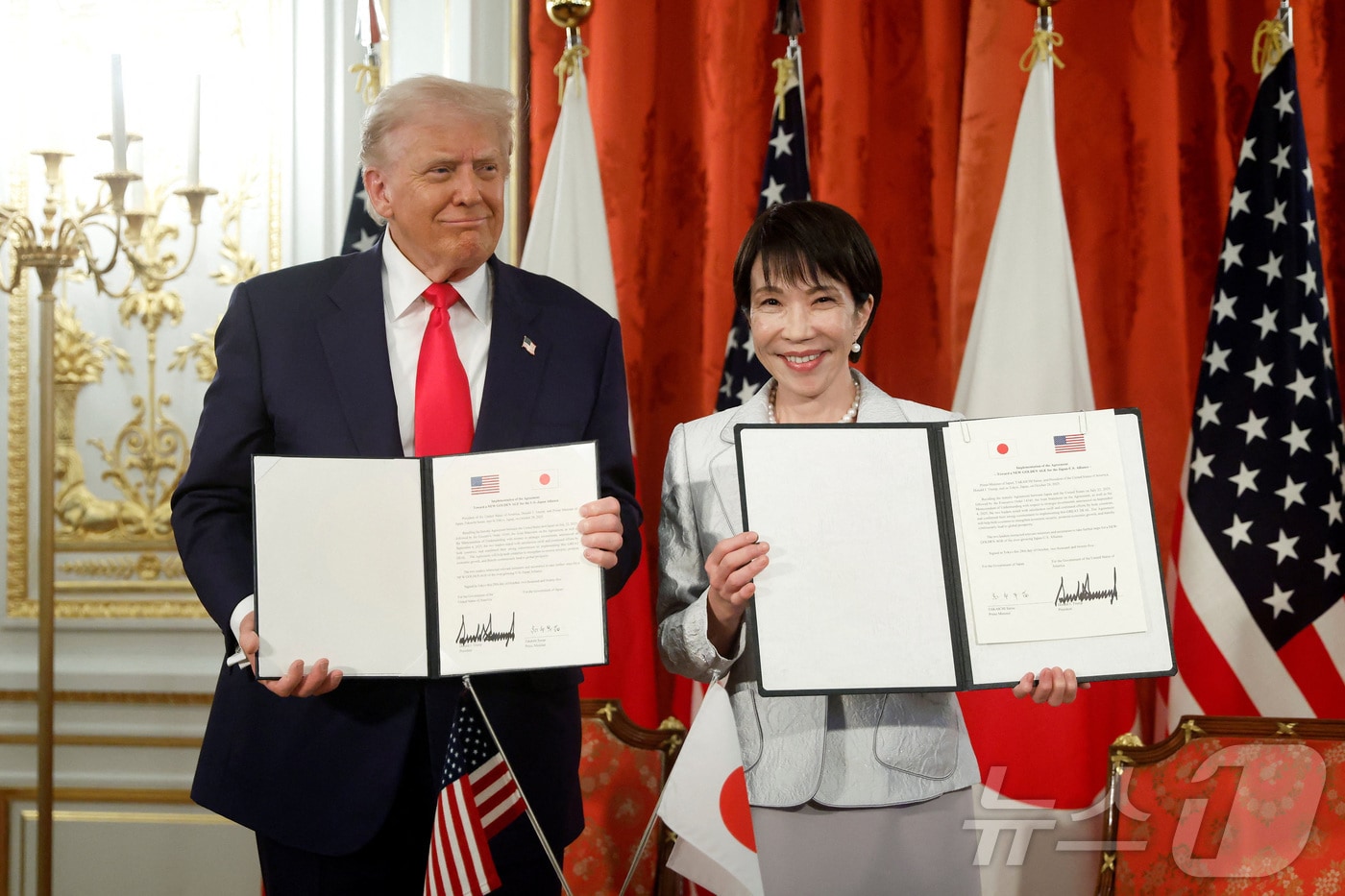 도널드 트럼프 미국 대통령과 다카이치 사나에 일본 총리가 2025년 10월 28일(현지시간) 도쿄 아카사카궁에서 미일 무역 협정에 서명한 뒤 이를 들어보이고 있다. ⓒ 로이터=뉴스1