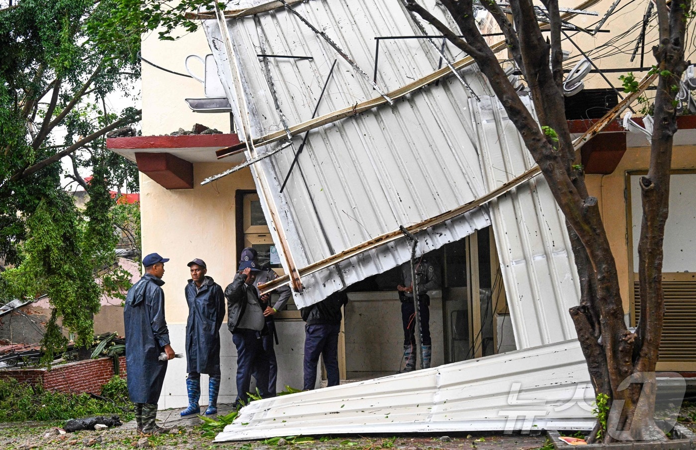 29일 쿠바 동부 산티아고데쿠바 지역에 허리케인 멜리사가 상륙하면서 주택과 도로에 침수 및 피해가 발생했다. AFP 현장 취재진에 따르면, 강력한 허리케인의 영향으로 국영 건물이 파손됐으며, 경찰이 해당 건물 외부를 경비하고 있는 모습. 2025.10.29.ⓒ AFP=뉴스1