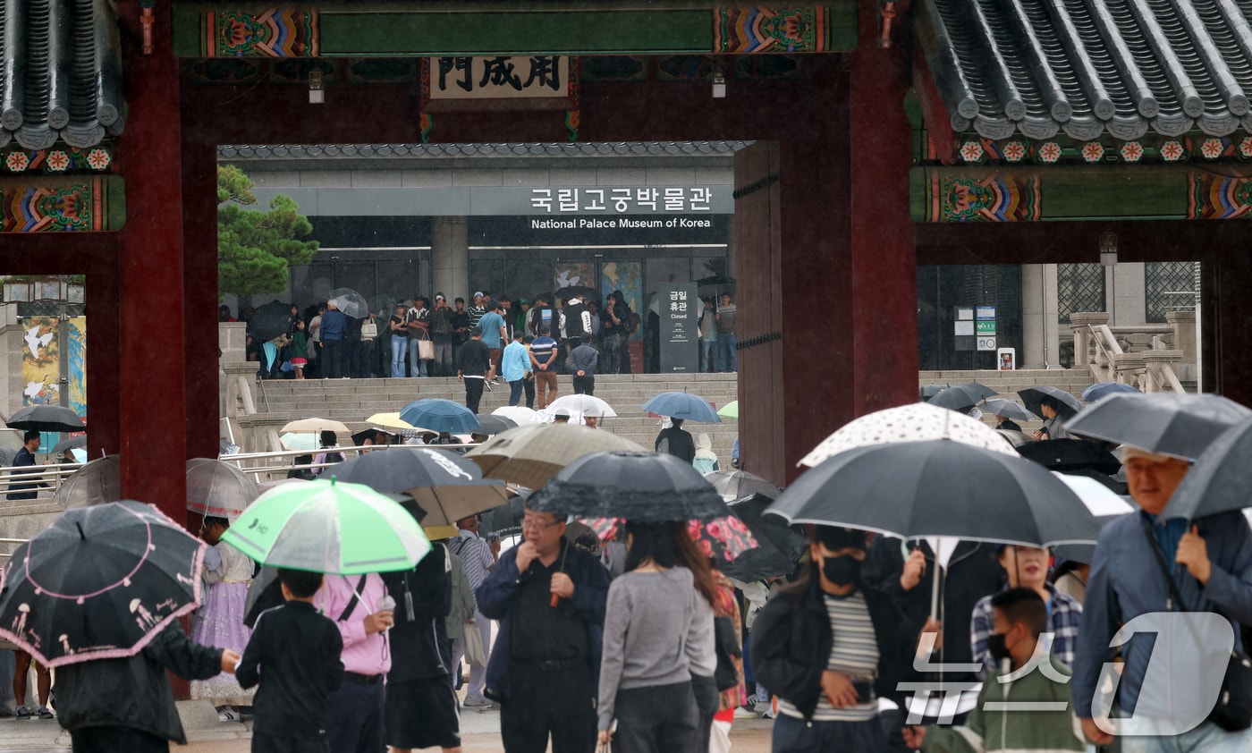 추석인 6일 서울 종로구 경복궁에서 비가 내리는 가운데 시민들과 외국인 관광객들이 나들이를 하고 있다. 추석 연휴 기간동안 경복궁, 창덕궁, 덕수궁, 창경궁 등 4대 궁과 종묘, 조선왕릉이 무료로 개방되어 누구나 자유롭게 관람할 수 있다. 2025.10.6/뉴스1 ⓒ News1 김명섭 기자