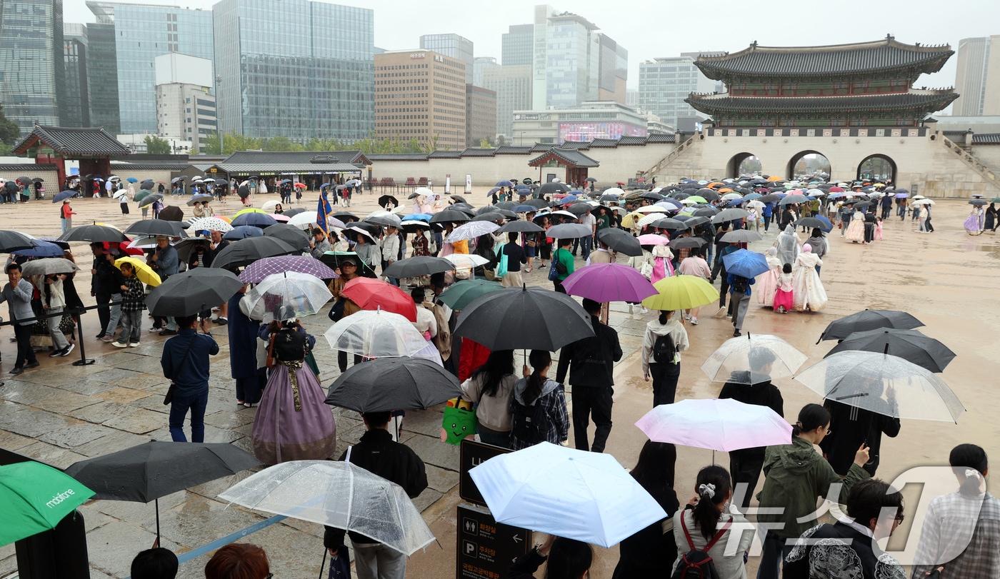 추석인 6일 서울 종로구 경복궁에서 비가 내리는 가운데 시민들과 외국인 관광객들이 나들이를 하고 있다. 추석 연휴 기간동안 경복궁, 창덕궁, 덕수궁, 창경궁 등 4대 궁과 종묘, 조선왕릉이 무료로 개방되어 누구나 자유롭게 관람할 수 있다. 2025.10.6/뉴스1 ⓒ News1 김명섭 기자