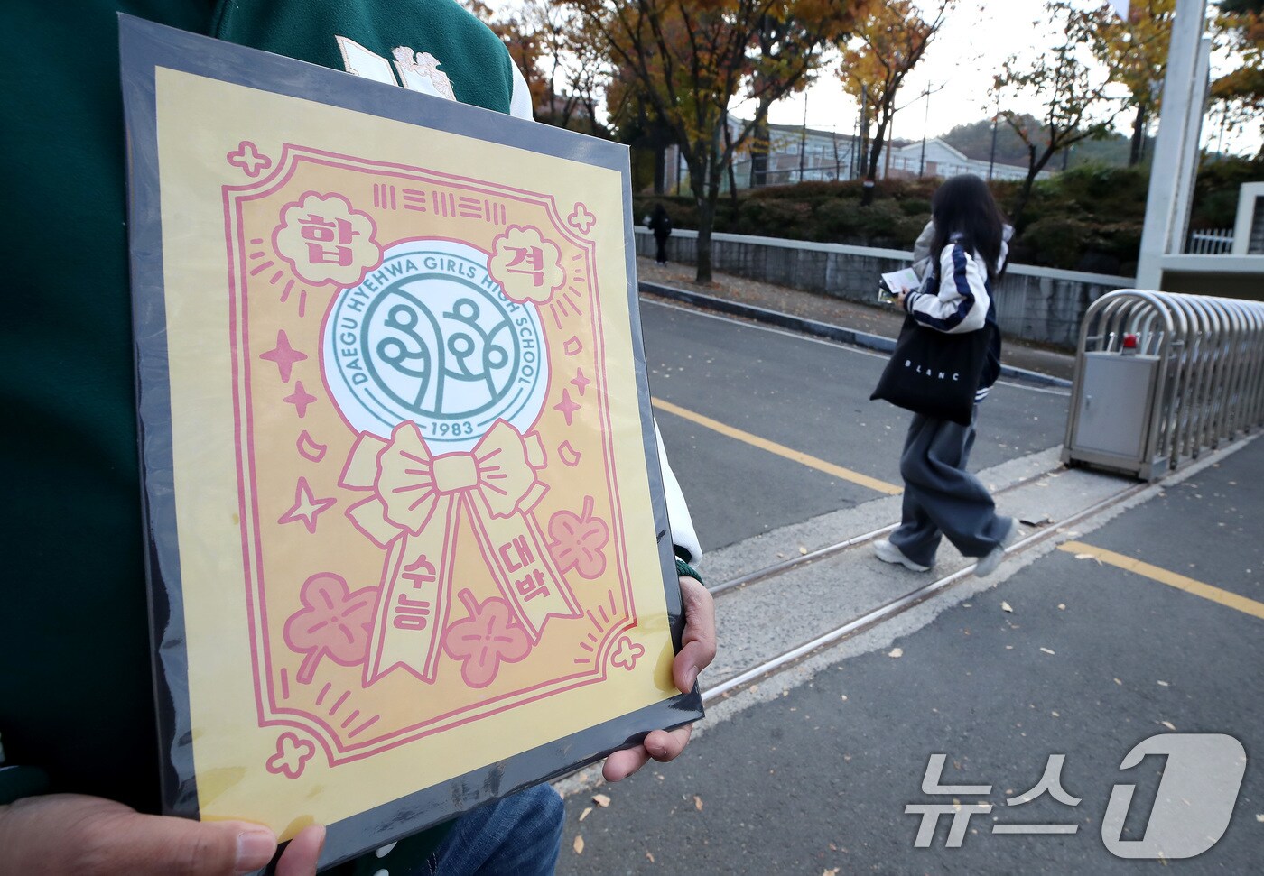 2026학년도 대학수학능력시험일인 13일 오전 대구 수성구 정화여고에 마련된 시험장 앞에서 한 교사가 부적을 손에 들고 출신학교 수험생을 응원하고 있다. (사진은 기사 내용과 무관함) 2025.11.13/뉴스1 ⓒ News1 공정식 기자