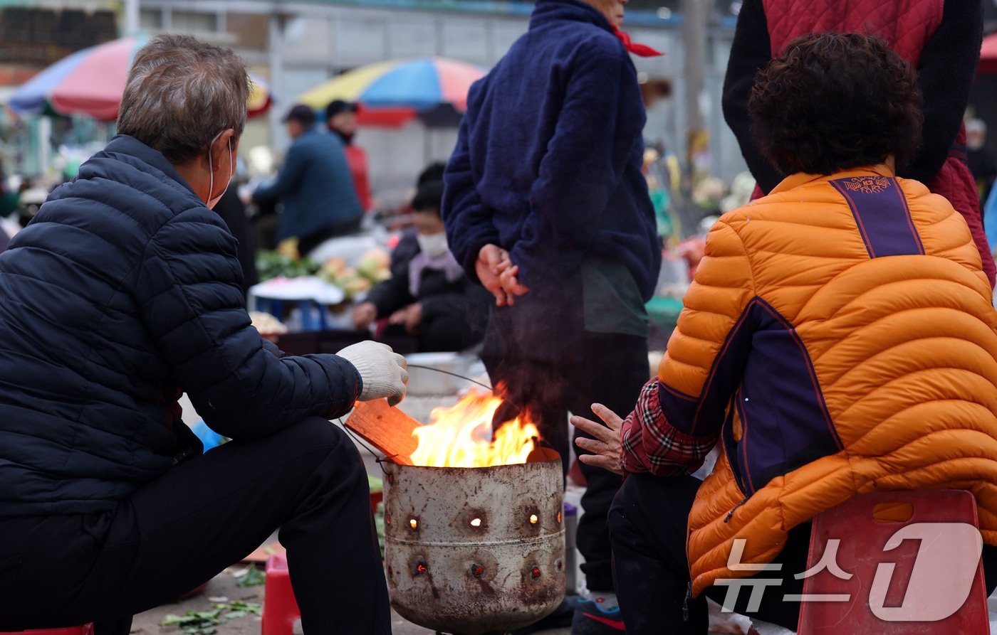 광주 동구 남광주시장 상인들이 추위를 피하기 위해 불을 쬐고 있다.  ⓒ News1 박지현 기자