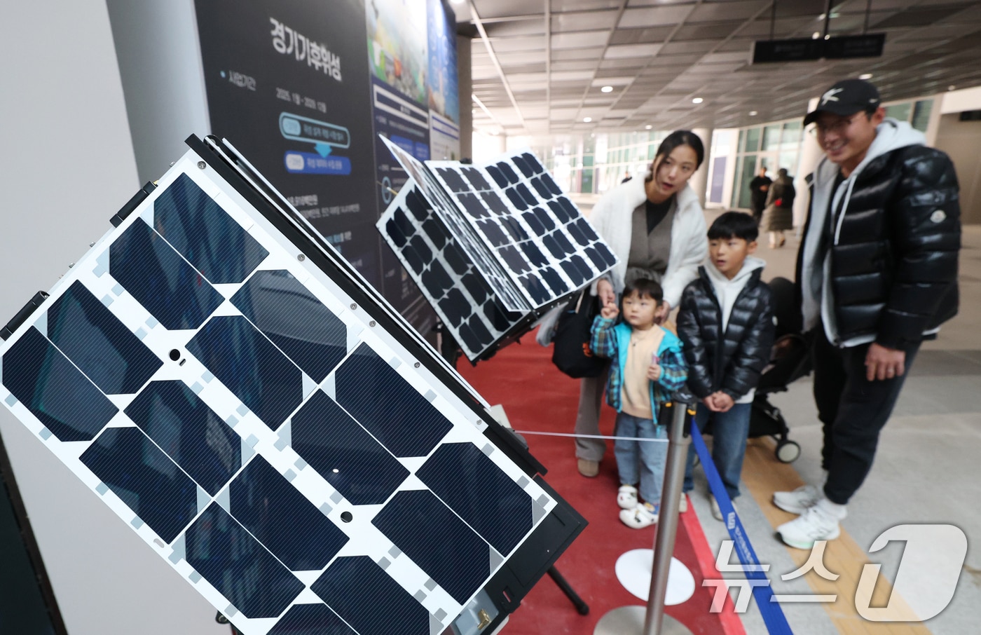 ‘경기 수원시 영통구 경기신용보증재단 도민쉼터에 마련된 경기기후위성 임시상황실에서 시민들이 &#39;경기기후위성&#39; 모형을 살펴보고 있다. /뉴스1