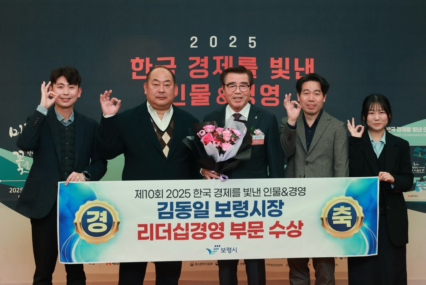 김동일 시장(가운데)이 '2025 한국 경제를 빛낸 인물·경영 시상식'에서 '리더십경영' 부문을 수상하고 홍보미디어실 직원들과 기념촬영을 하고 있다.(보령시 제공. 재판매 및 DB금지)/뉴스1