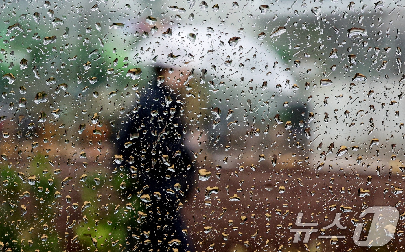 전창 밖으로 우산을 쓴 시민이 발걸음을 옮기고 있다. /뉴스1 ⓒ News1 이호윤 기자