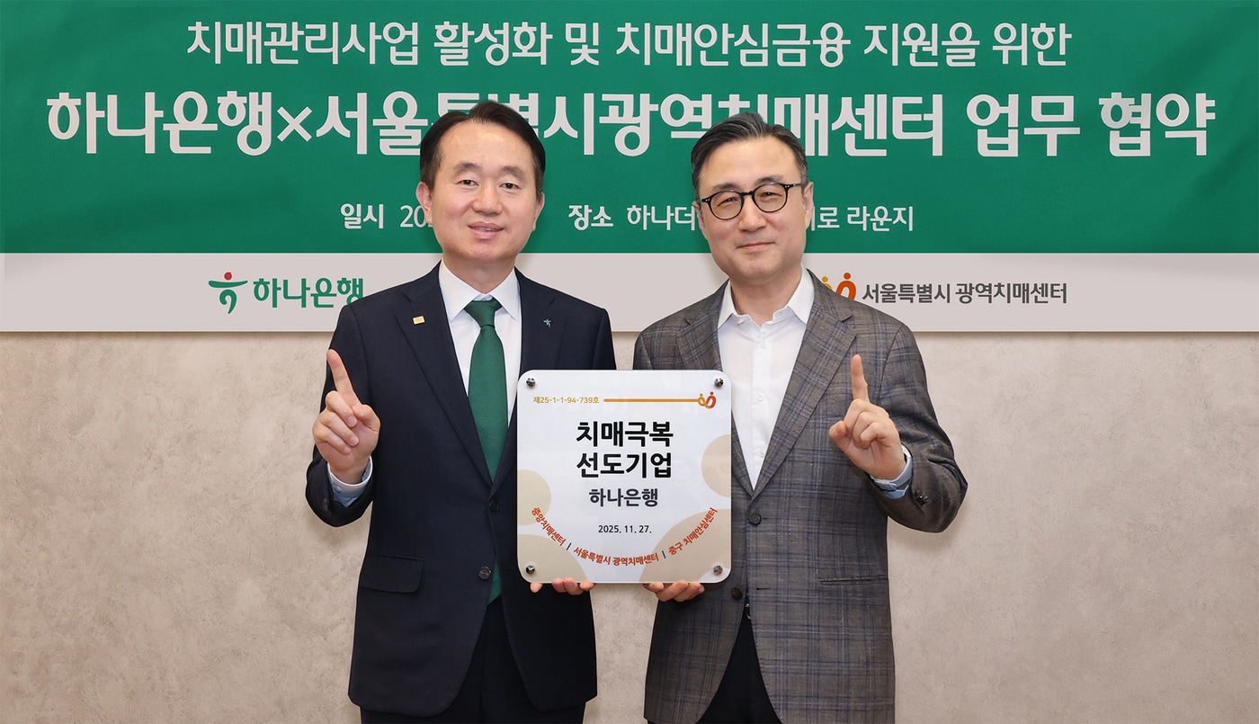 김영훈 하나은행 자산관리그룹 부행장(왼쪽)과 이동영 서울특별시광역치매센터장(오른쪽)이 ‘치매극복선도기업’ 현판을 전달하고 기념촬영을 하고 있다 (하나은행 제공)