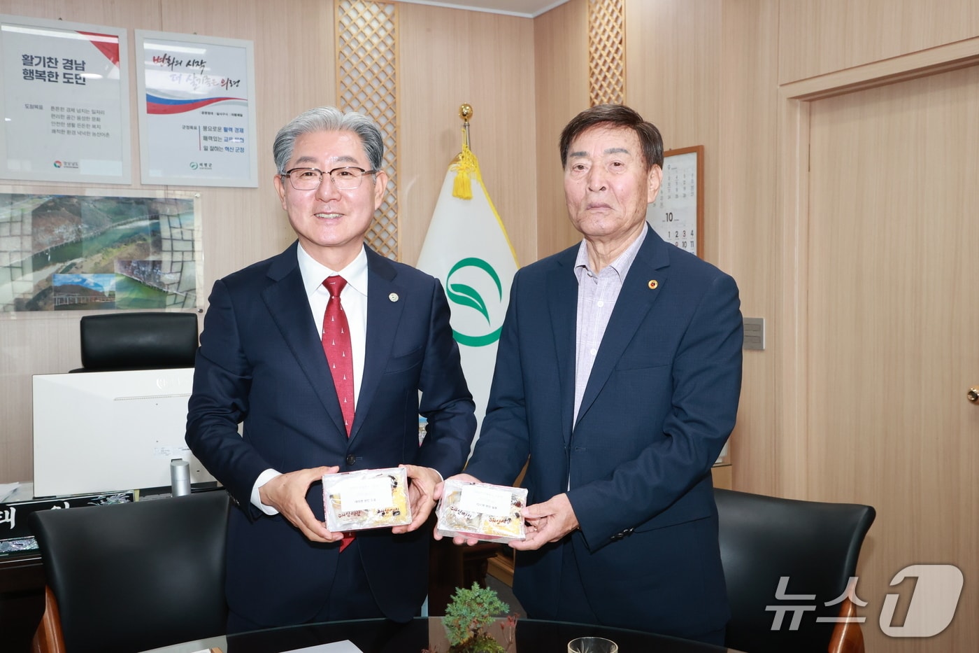 황진탁씨(오른쪽)가 지난달 30일 의령군청 군수실에서 오태완 군수에게 감사의 마음을 전한 떡을 전달하고 있다(의령군 제공. 재판매 및 DB금지).