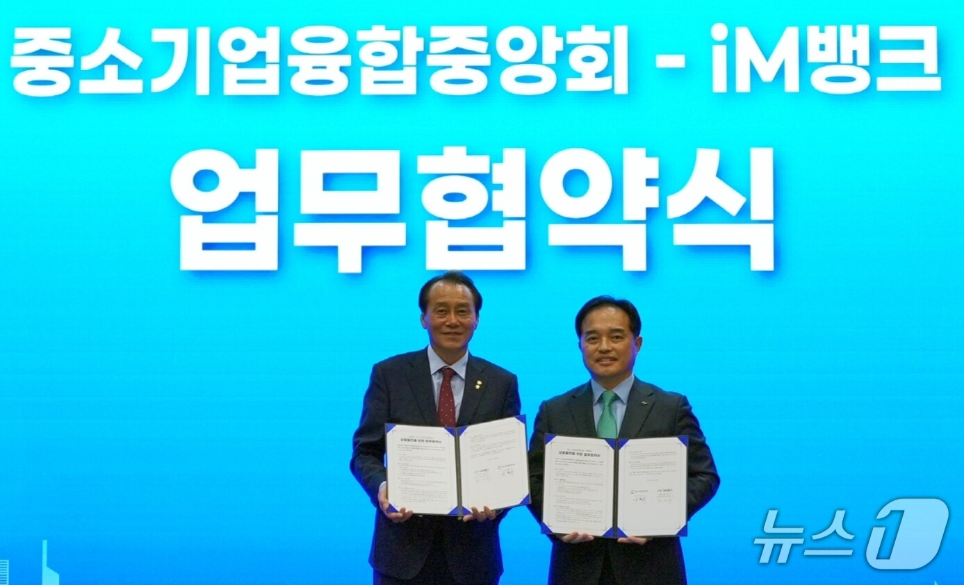 강환수 중소기업융합중앙회 회장(왼쪽)과 최상수 iM뱅크 마케팅그룹장이 전국 중소기업 경쟁력 강화 및 상호발전을 위한 업무협약을 체결한 후 협약서를 펼쳐 보이고 있다.(iM뱅크 제공, 재판매 및 DB 금지)