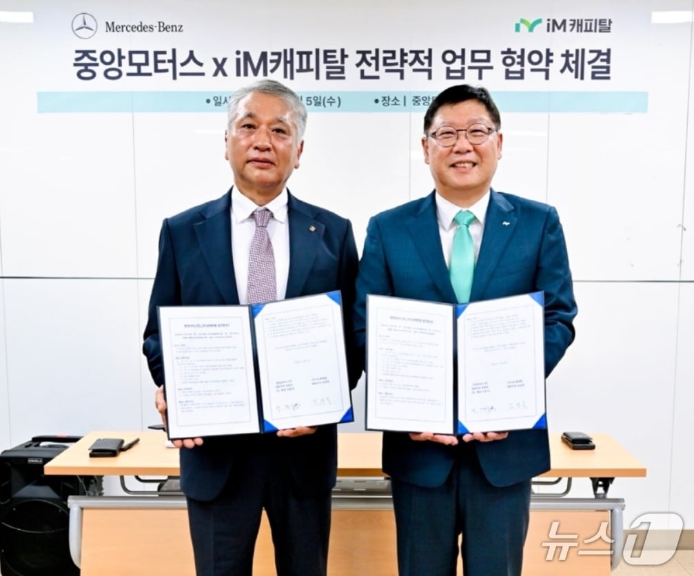 김성욱 iM캐피탈 대표이사(오른쪽)와 이종기 중앙모터스 회장이 전략적 전속 금융 업무협약을 체결한 후 협약서를 펼쳐 보이고 있다.(iM뱅크 제공, 재판매 및 DB 금지)