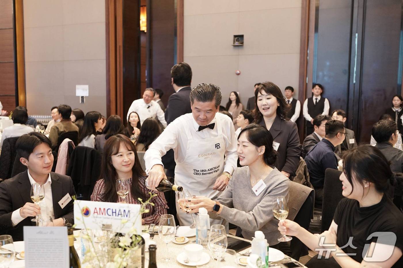 제임스 김 주한미국상공회의소(암참) 회장(왼쪽 세번째)이 6일 서울 여의도 콘래드 서울에서 열린 '암참 최고경영자(CEO) 서버스 나이트'에서 참석자들에게 와인을 따라주고 있다.(암참 제공)