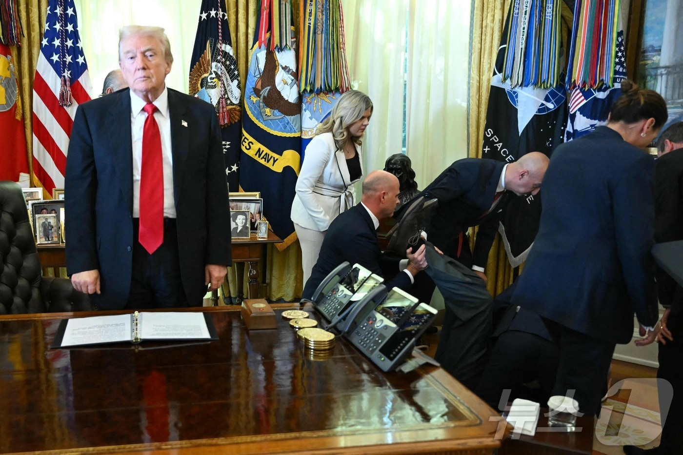 도널드 트럼프 미국 대통령이 6일(현지시간) 워싱턴DC 백악관 집무실에서 비만 치료제에 관해 발표하던 중 노보 노디스크 임원 고든 핀들레이가 돌연 실신하자 동석자들이 몰려들고 있다. 2025.11.06. ⓒ AFP=뉴스1 ⓒ News1 윤다정 기자