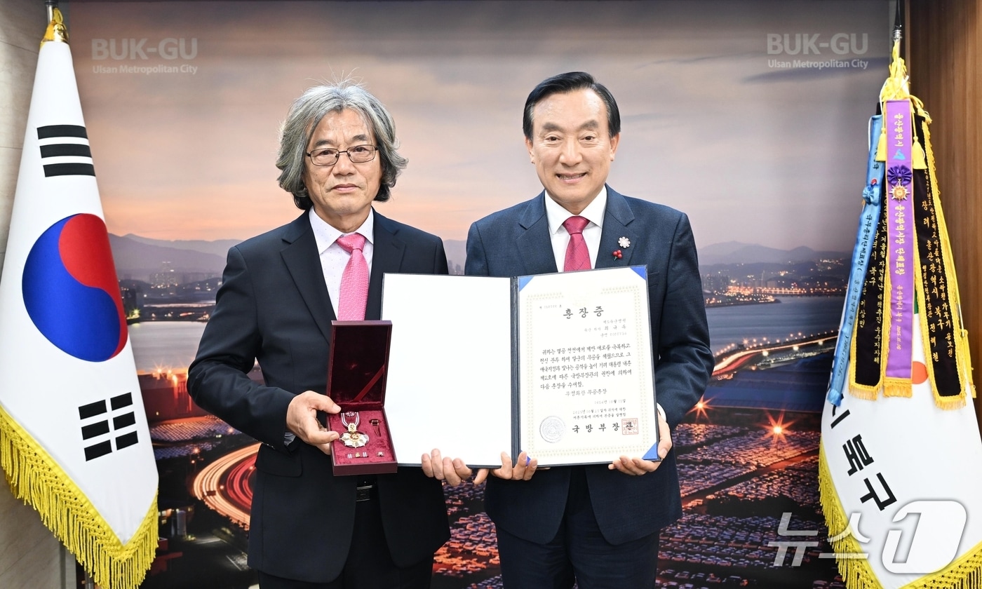 박천동 울산 북구청장(오른쪽)이 1일 구청장실에서 6·25전쟁 당시 혁혁한 무공을 세우고 전사한 고(故) 최규옥 하사의 유족(왼쪽)에게 무성화랑 무공훈장과 훈장증을 전수했다.(울산 북구 제공. 재판매 및 DB금지)/뉴스1