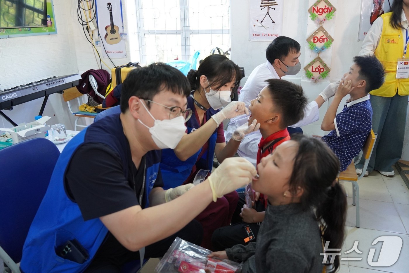 분당제생병원 치과 의료진과 베트남 현지 의료진이 어린이 구강상태를 살피고 불소도포를 하고 있다.&#40;분당제생병원 제공&#41;