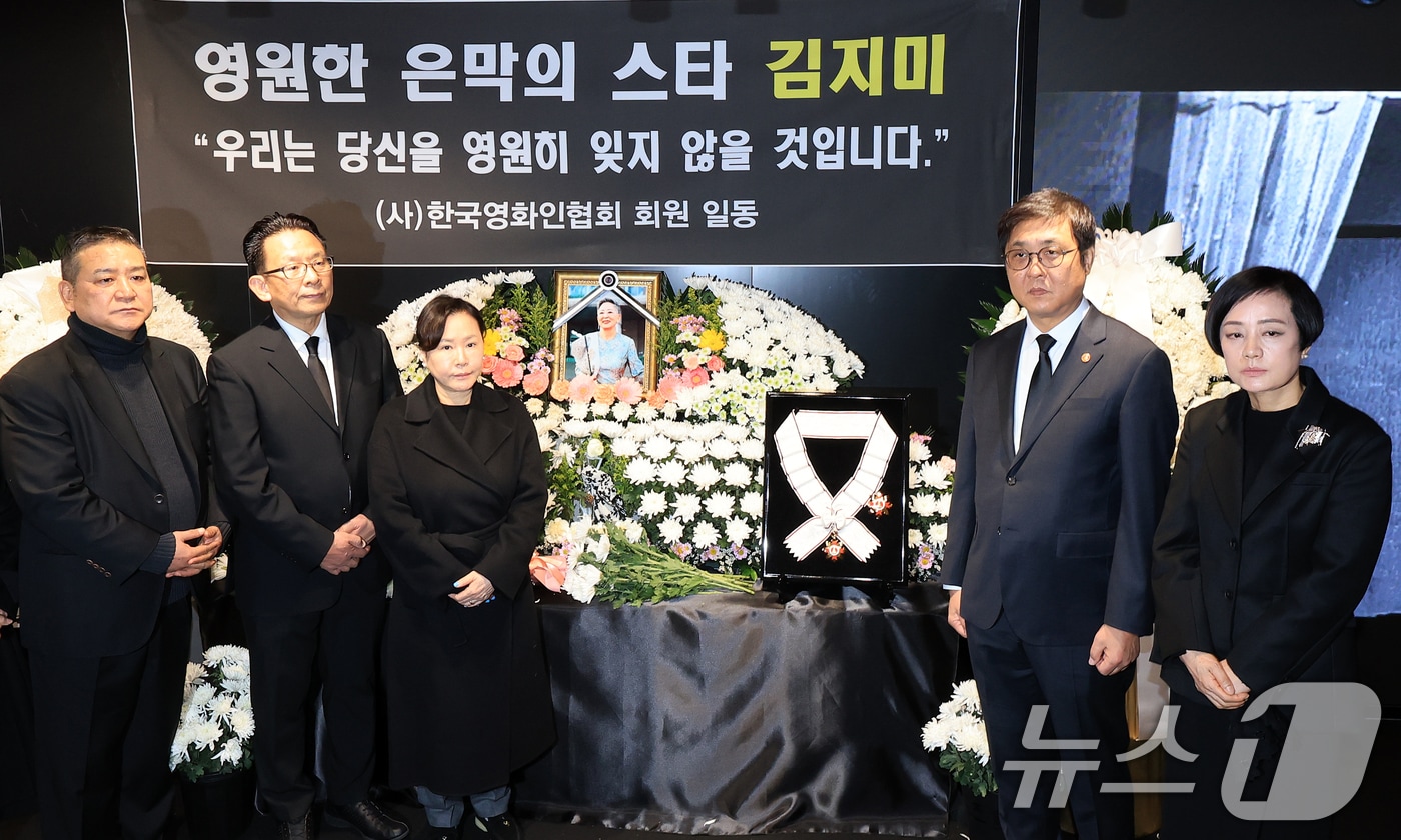 최휘영 문화체육관광부 장관(오른쪽 두 번째)이 14일 서울 중구 서울영화센터에 마련된 고 김지미 배우의 추모공간을 찾아 금관문화훈장을 전달한 뒤 유가족 및 영화업계 관계자들과 기념촬영을 하고 있다. 2025.12.14/뉴스1 ⓒ News1 이호윤 기자