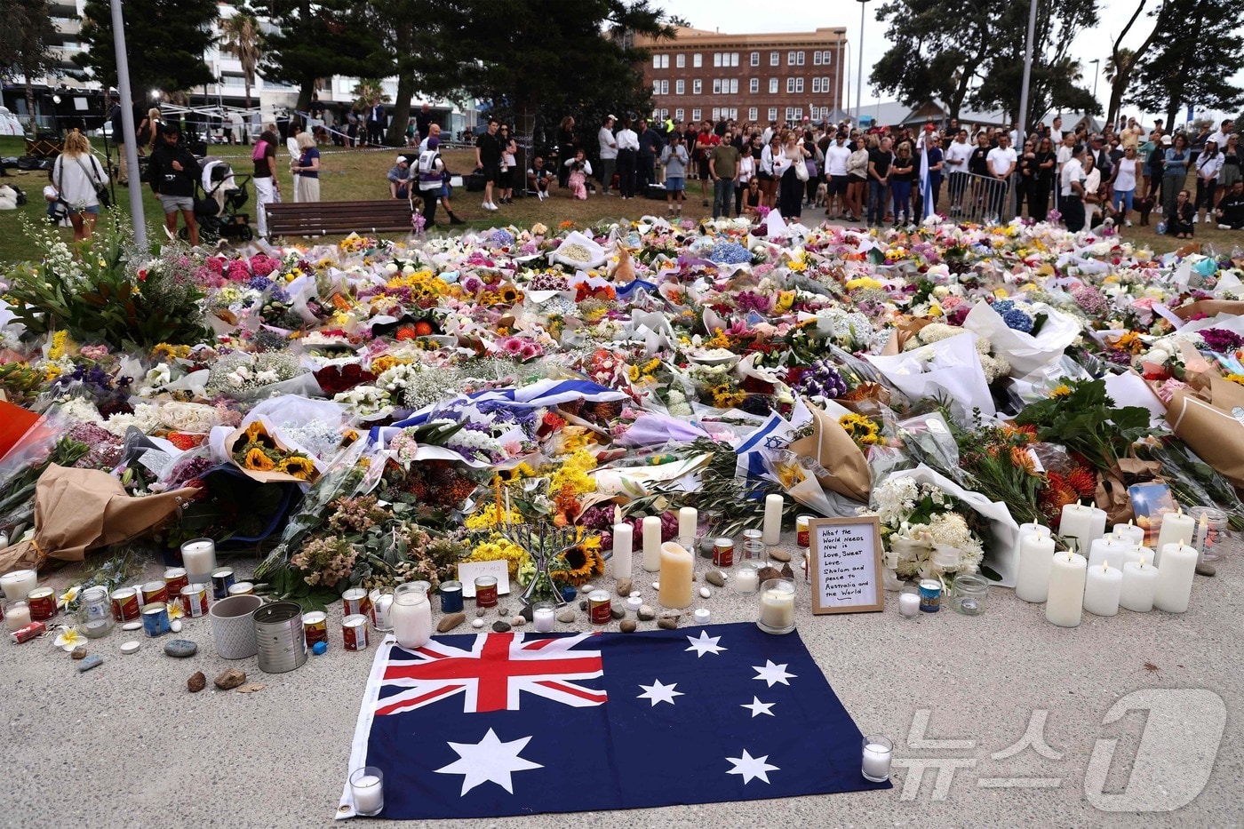 16일(현지시간) 호주 시드니 본다이 비치의 본다이 파빌리온에 마련된 총기 난사 희생자 추모소에서 시민들이 희생자들을 애도하고 있다. ⓒ AFP=뉴스1 ⓒ News1 송원영 기자
