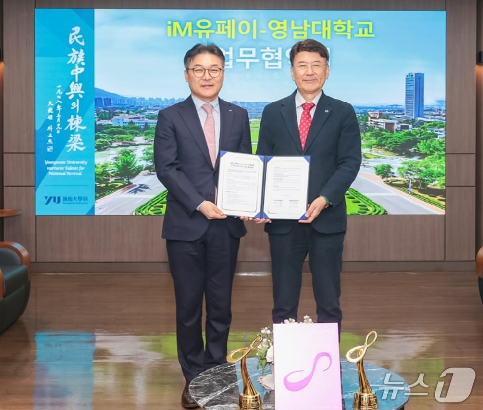 윤재웅 iM유페이 대표이사(왼쪽)와 최외출 영남대 총장이 청년 교통복지 확대와 스마트 캠퍼스 구축을 위한 업무협약을 체결한 후 협약서를 펼쳐 보이고 있다.(iM뱅크 제공, 재판매 및 DB 금지)