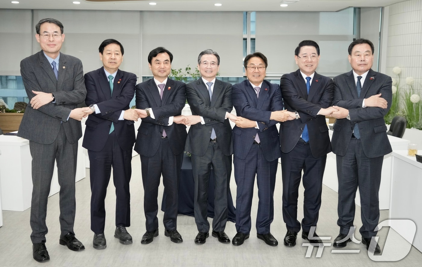 17일 오전 광주 서구 광주도시공사에서 열린 광주군공항이전 6자협의체회의에 참석한 내빈들이 손을 맞잡고 기념사진을 촬영하고 있다. 왼쪽부터 강희업 국토교통부 제2차관, 구윤철 기획재정부장관, 안규백 국방부장관, 김용범 대통령비서실 정책실장, 강기정 광주시장, 김영록 전남도지사, 김산 전남무안군수. (광주시 제공. 재판매 및 DB 금지) 2025.12.17/뉴스1 