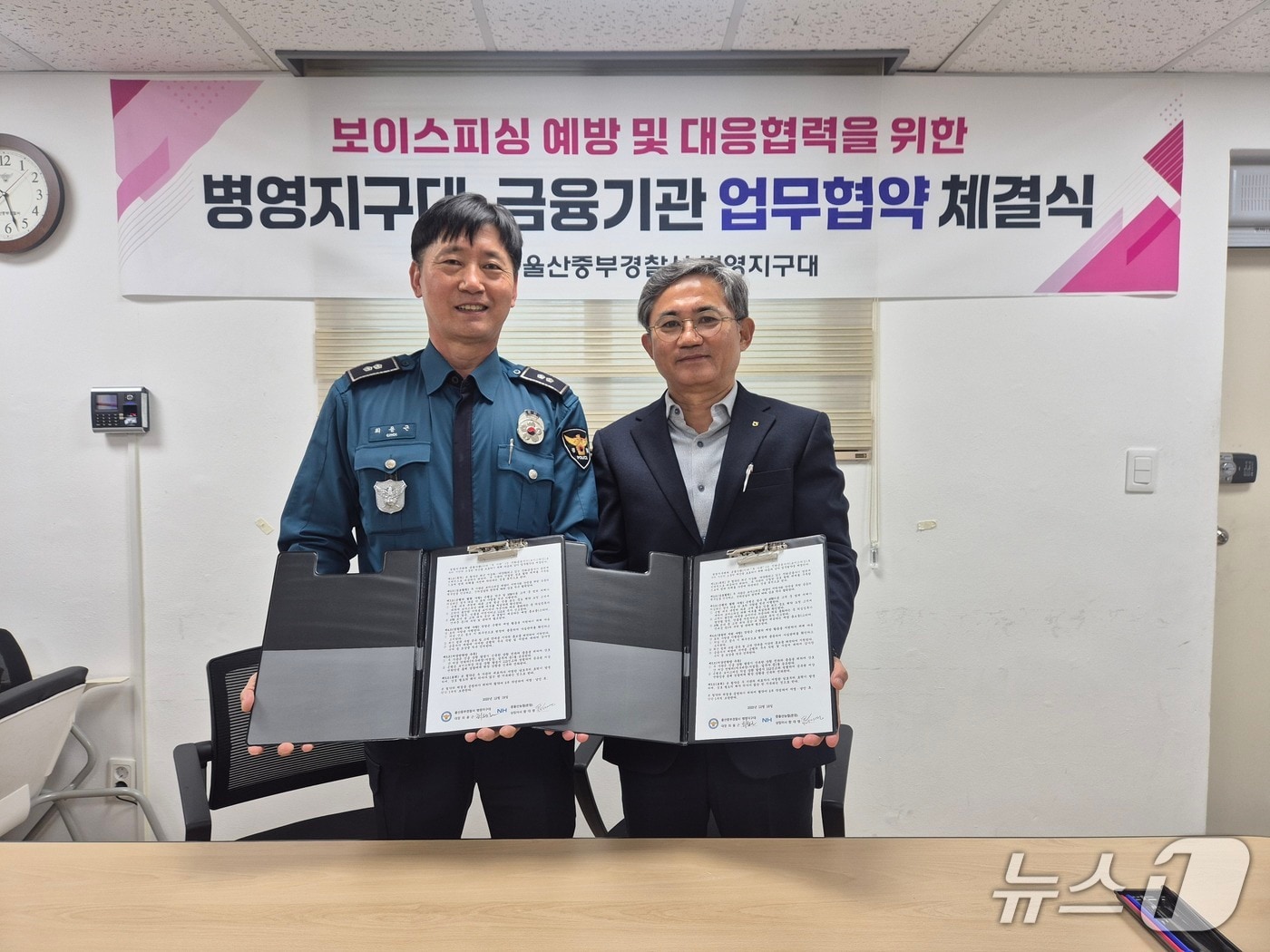 최용근 병영지구대장과 함대영 중울산농협 상임이사가 18일 지구대에서 보이스피싱 예방 및 근절을 위한 업무협약(MOU)을 체결했다.(울산중부경찰서 제공. 재판매 및 DB금지)/뉴스1