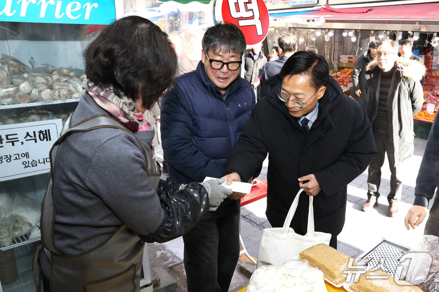 김용선 지식재산처장(왼쪽에서 3번째)이 북수원시장 상점을 방문해 물품을 구매하고 있다.(지식재산처 제공.재판매 및 DB 금지)/뉴스1 