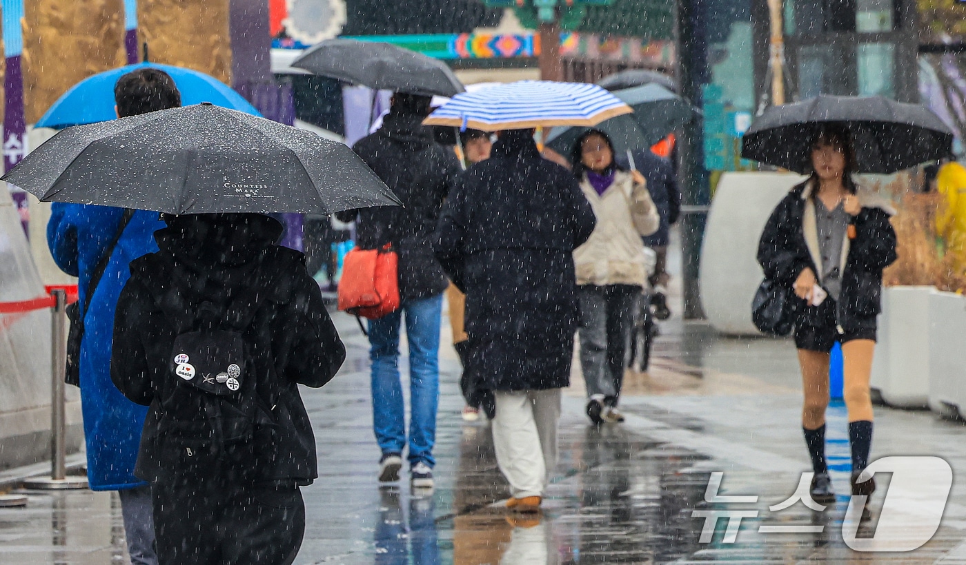 크리스마스 이브를 앞두고 진눈깨비가 내린 23일 서울 종로구 광화문광장에서 시민들이 발걸음을 재촉하고 있다. 2025.12.23/뉴스1 ⓒ News1 이호윤 기자