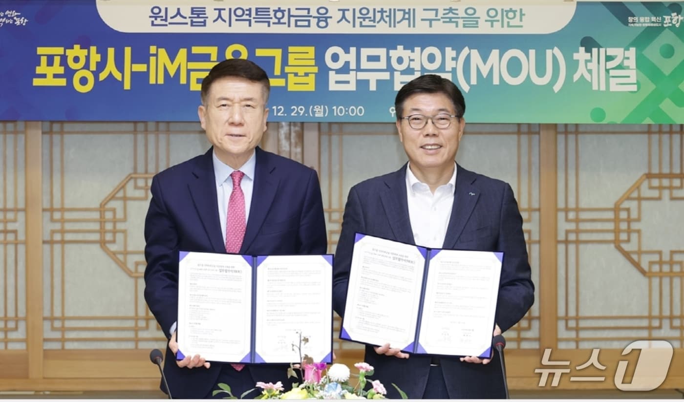 황병우 iM금융그룹 회장(오른쪽)과 이강덕 포항시장이 '원스톱 지역특화금융 지원체계 구축을 위한 업무협약'을 체결한 뒤 협약서를 펼쳐 보이고 있다.(iM뱅크 제공, 재판매 및 DB 금지)