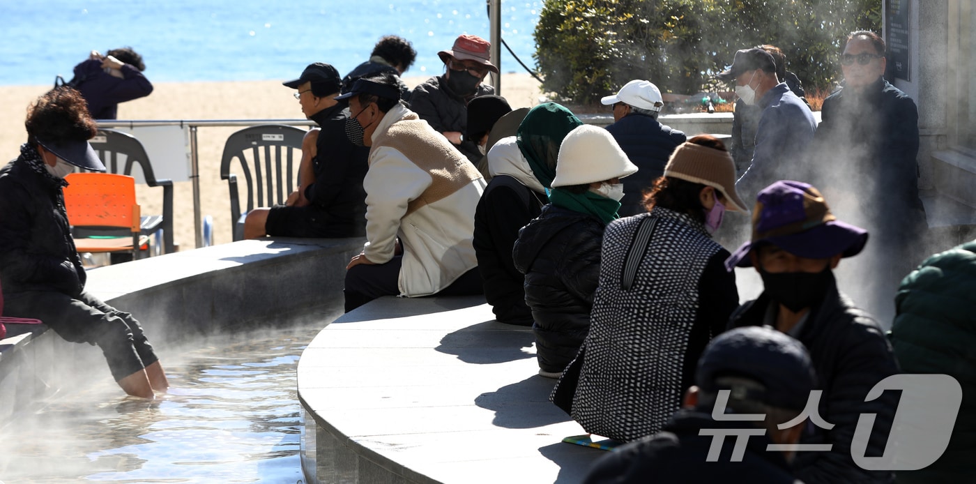 부산 해운대해수욕장 온천족욕탕을 찾은 시민들이 따뜻한 온천물에 발을 담그고 추위를 녹이고 있다. 2025.12.3/뉴스1 ⓒ News1 윤일지 기자