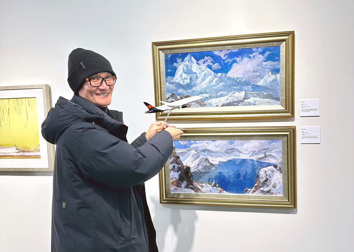 에어프레미아에 고용된 청각장애 예술인 오효석 작가가 30일 경기 과천 소재 장애예술인 전문 전시관 '갤러리 바다'에서 자신이 그린 작품과 함께 기념 사진을 촬영한 모습(에어프레미아 제공). 2025.12.30.