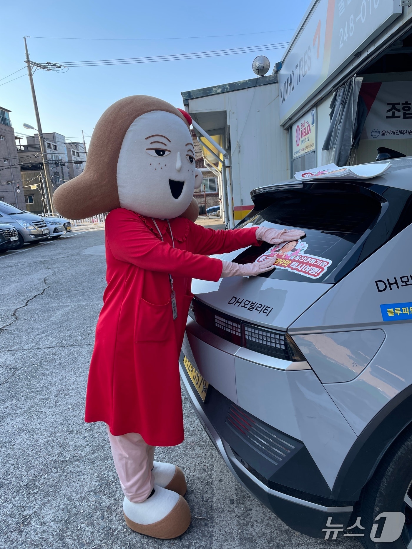 울산 중구 대표 캐릭터인 울산큰애기가 택시 뒷유리에 중구 관광 홍보물을 붙이고 있다.(울산 중구 제공. 재판매 및 DB금지)/뉴스1