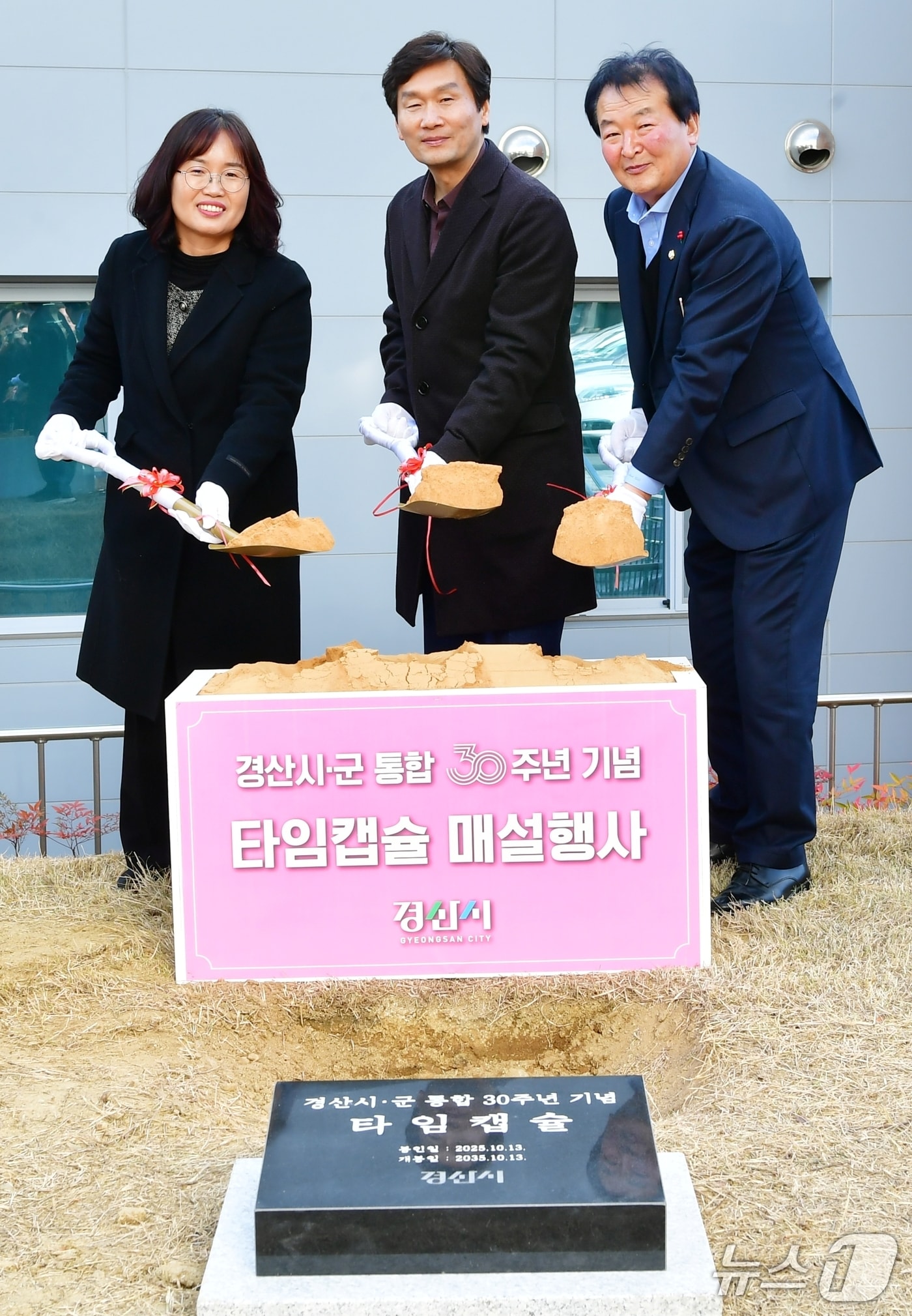 조현일 경산시장(가운데)이 31일 시청 마당에서 시군통합 30주년 기념 타임캡슐을 매설하고 있다. (경산시 제공. 재판매 및 DB금지)/뉴스1