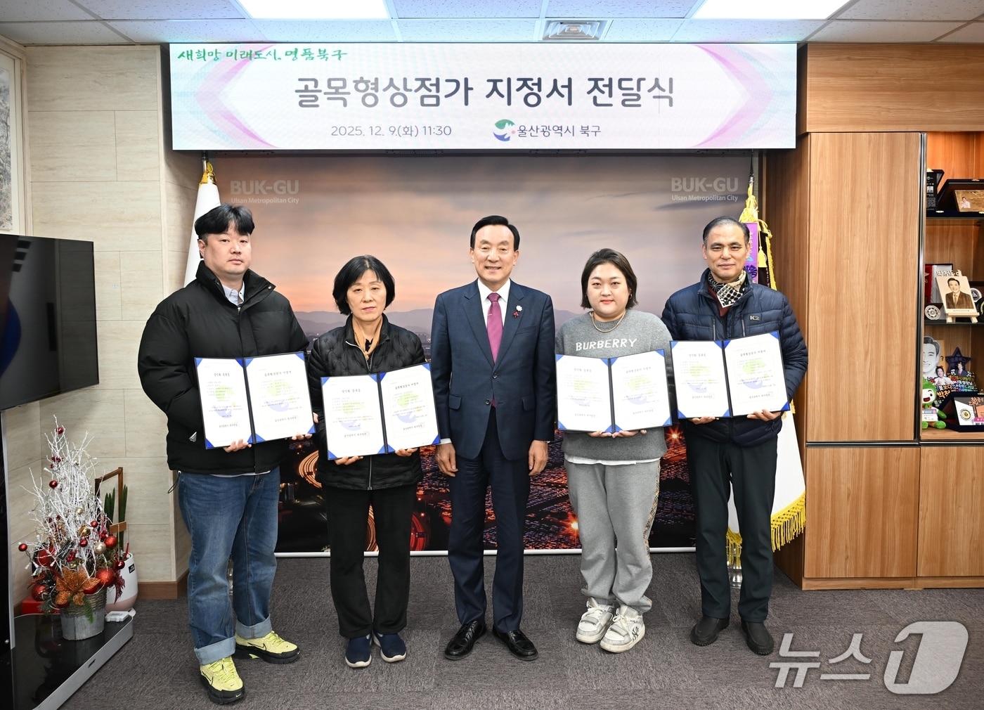 울산 북구는 최근 추가 지정된 골목형상점가 5곳에 9일 지정서를 전달하고 기념사진을 찍고 있다.(울산 북구 제공. 재판매 및 DB금지)/뉴스1