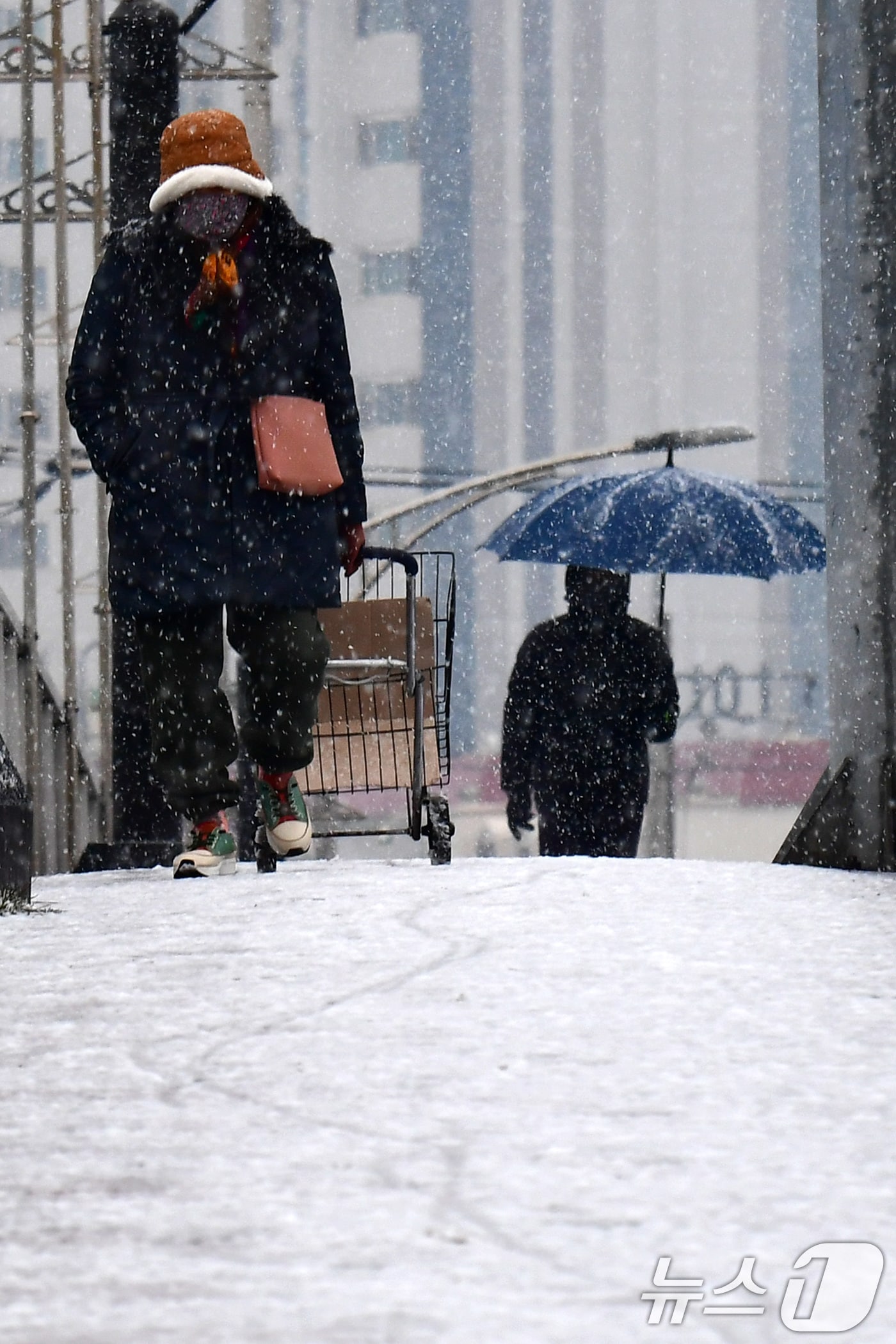 12일 경북 포항지역 아침부터 눈이 내린 가운데 북구 동빈대교를 건너는 시민들이 내리막길을 조심조심 걷고 있다. 2025.2.12/뉴스1 ⓒ News1 최창호 기자