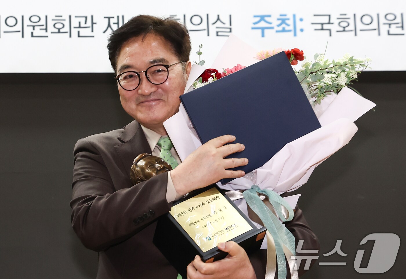 우원식 국회의장이 14일 오전 서울 여의도 국회 의원회관에서 열린 '제9회 민주주의자 김근태상 시상식'에서 김근태상 상패와 꽃다발을 들고 미소를 보이고 있다. 2025.2.14/뉴스1 ⓒ News1 김민지 기자