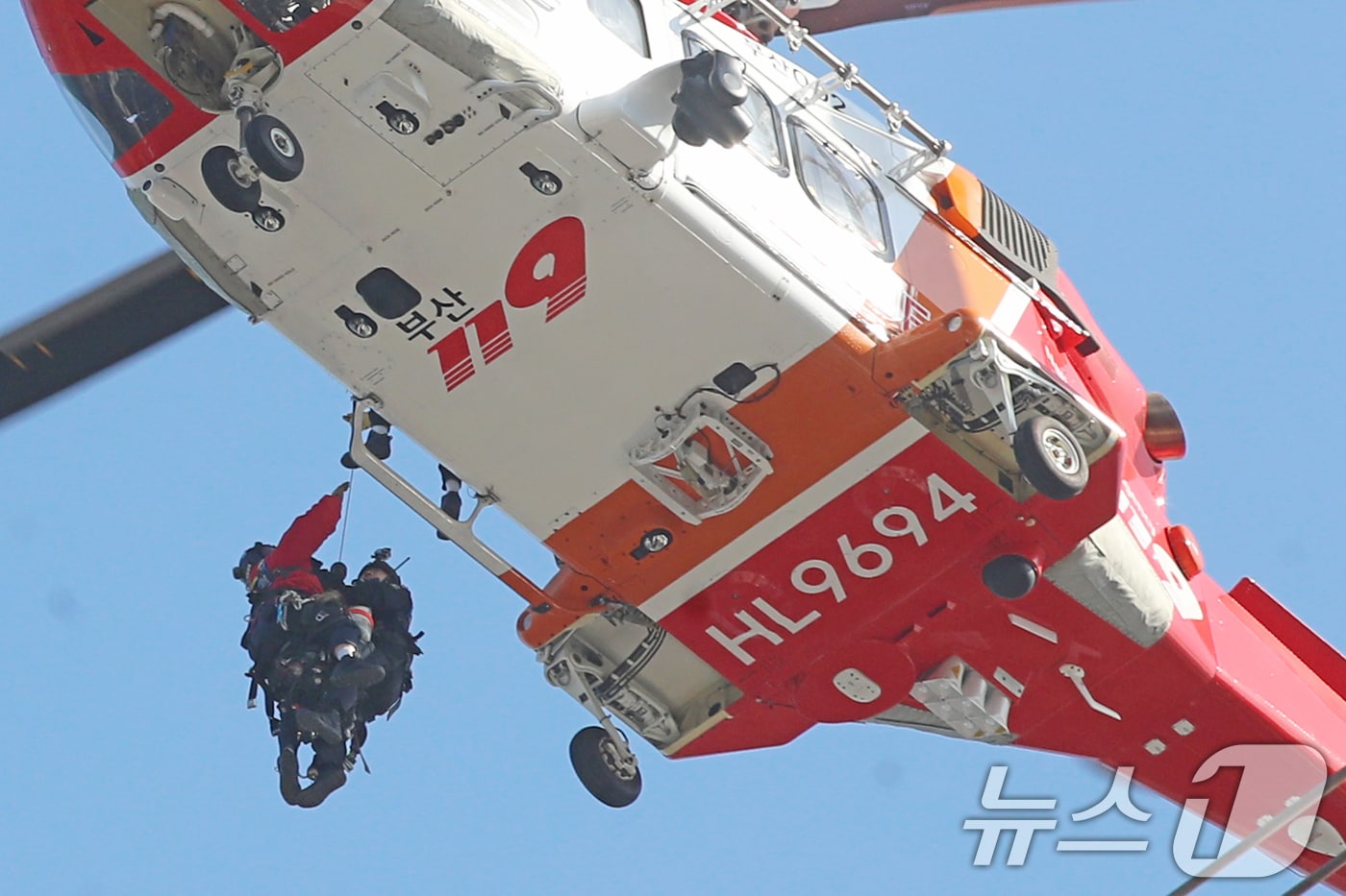 14일 부산 기장군 반얀트리 호텔 신축 공사장에서 화재가 발생해 소방대원들이 헬기를 동원해 옥상으로 대피한 인부를 구조하고 있다. 2025.2.14/뉴스1 ⓒ News1 윤일지 기자