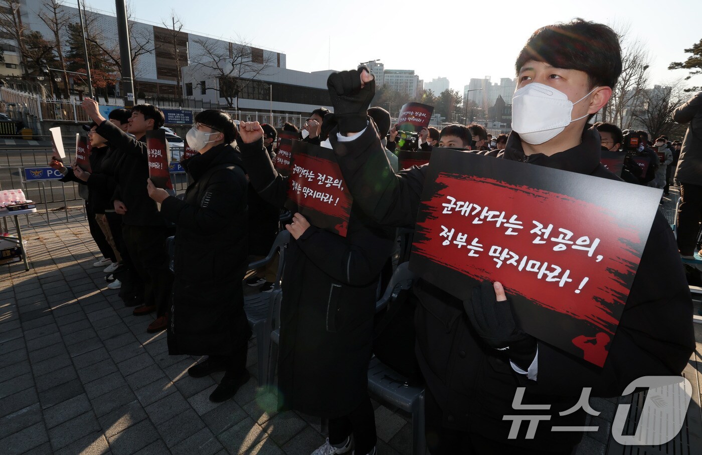 군 미필 사직 전공의들이 22일 서울 용산구 국방부 앞에서 ‘의무·수의 장교의 선발 및 입영에 관한 훈령 개정안 반대’ 집회를 갖고 구호를 외치고 있다. 2025.2.22/뉴스1 ⓒ News1 박세연 기자