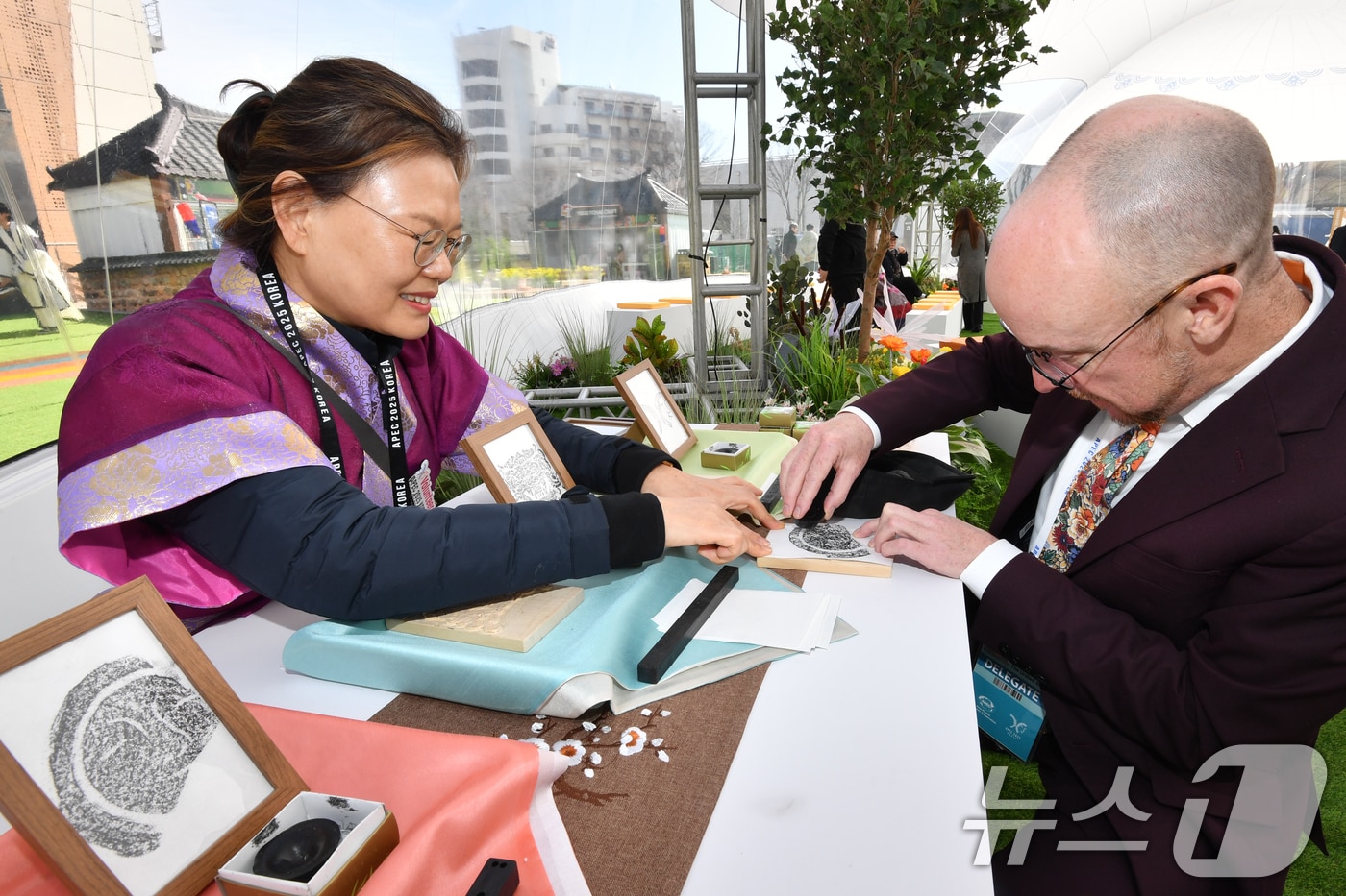 APEC 2025 KOREA (SOM1) 고위관리회의 둘째날인 25일 회의장인 경북 경주시 보문단지 경주컨벤션센터(HICO) 야외에 마련된 투명 돔 공연장에서 미국 관계자가 신라의 미소 탁본을 직접 만들어 보고 있다. 이번 회의는 24일부터 다음 달 9일까지 HICO에서 APEC 21개 회원국 대표단 등 2000여명이 28개 회의체를 구성해 총 100여 차례의 회의를 개최한다. 2025.2.25/뉴스1 ⓒ News1 최창호 기자