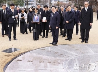 고 홍선기 전 대전시장 유가족이 28일 고인의 영정 사진을 들고 대전시청 남문 앞에 설치된 역대 대전시장의 이름이 새겨진 표지석에 잠시 멈춰 서 있다.(대전시 제공)/뉴스1 