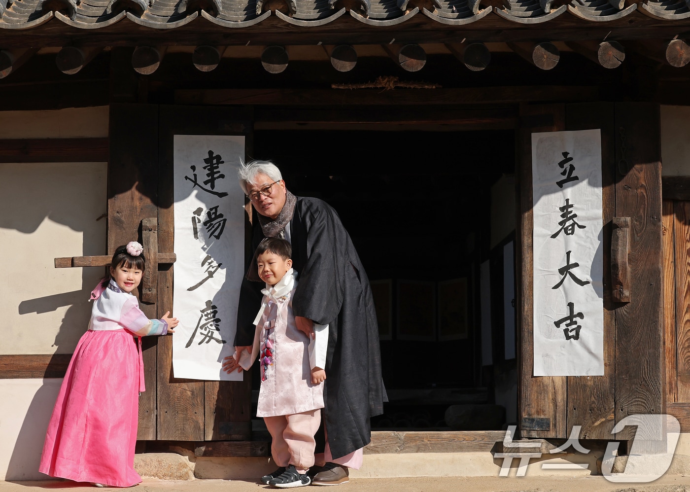 절기상 입춘(立春)인 3일 서울 종로구 국립민속박물관 내 오촌댁 대문에 서예가와 어린이들이 입춘첩을 붙이고 있다. 2024.2.3/뉴스1 ⓒ News1 오대일 기자