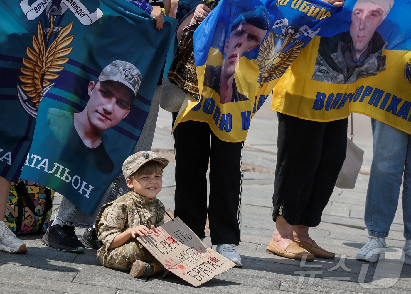 2024년 5월 23일 군복을 입은 소년이 '내 형제를 데려오라'는 문구가 새겨진 현수막을 들고 있다. 2024.05.23 ⓒ 로이터=뉴스1 ⓒ News1 김경민 기자