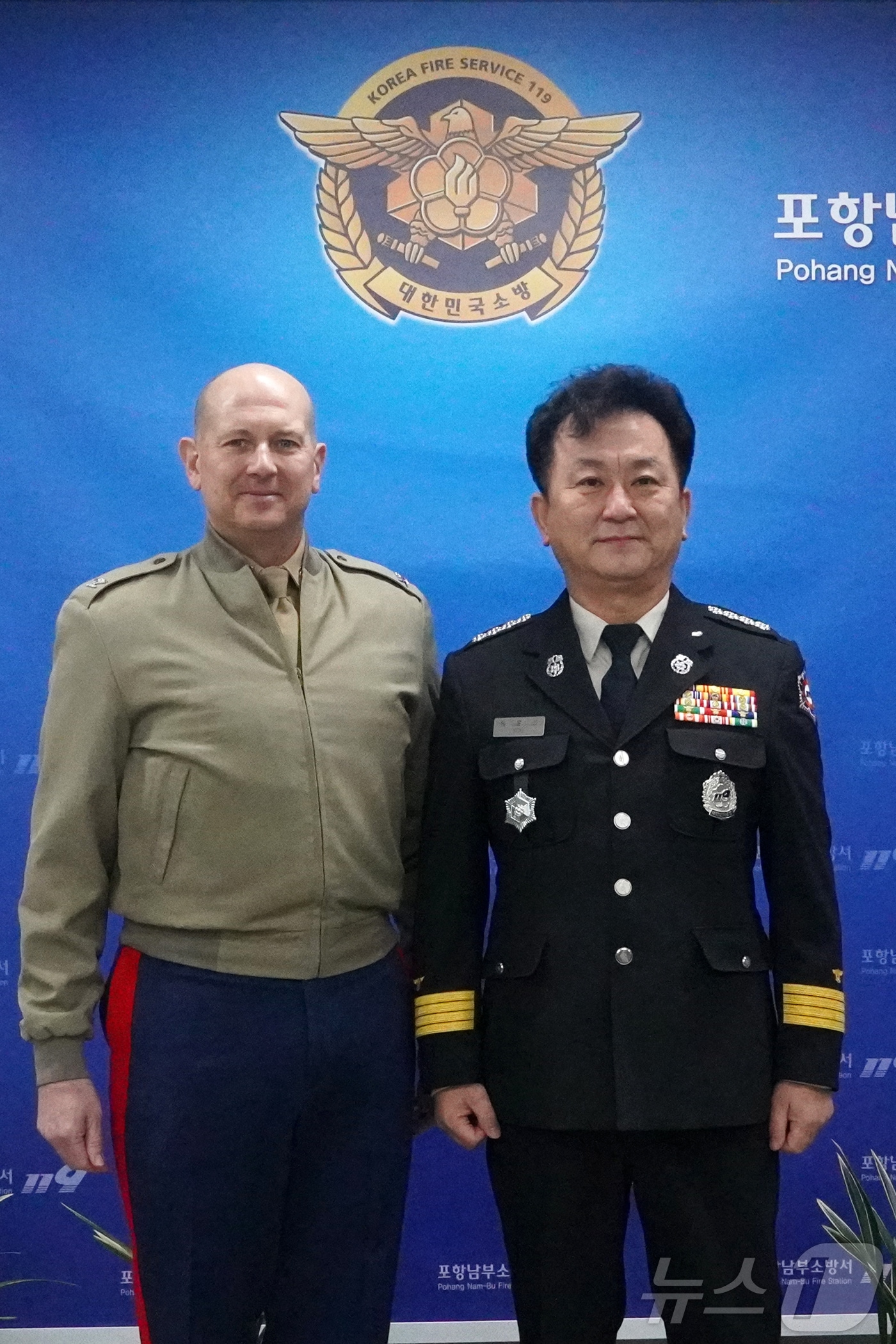 유뮤선 경북 포항남부소방서장과 미 해병대 로니 마이클 부대장이 5일 긴급 대응체계를 확인한 후 기념촬영을 하고 있다. (포항남부소방서 제공) 2025.2.5/뉴스1