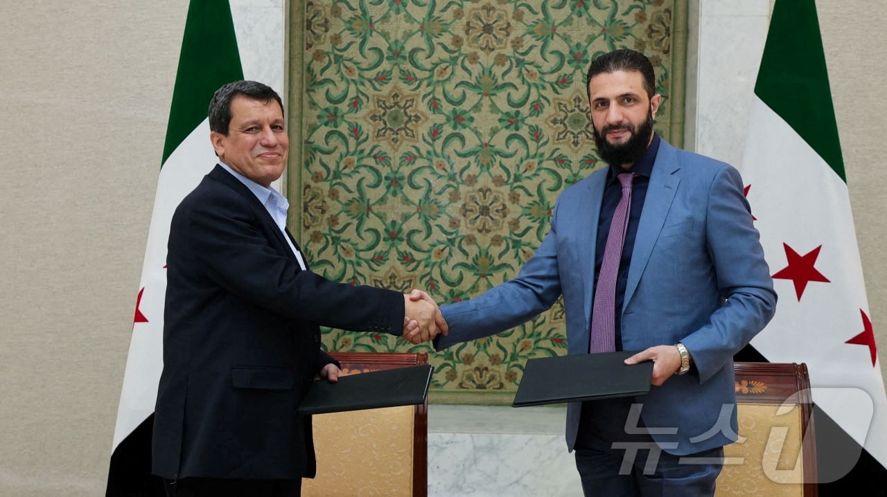 아메드 알샤라 시리아 임시대통령(오른쪽)과 마즐룸 압디 SDF 총사령관은 10일(현지시간) 이같은 합의하고 악수하고 있다. 2025.03.10. ⓒ 로이터=뉴스1