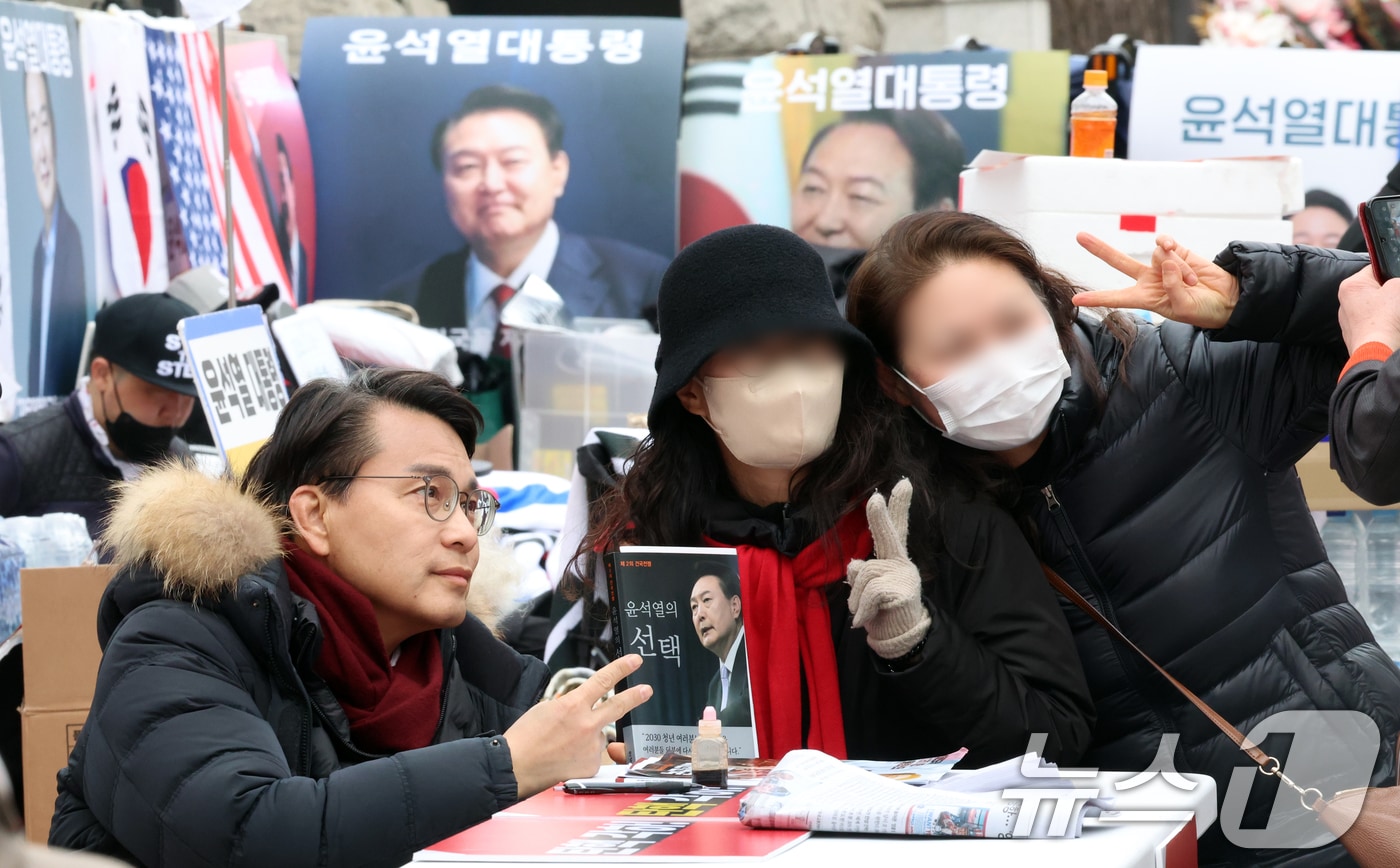윤상현 국민의힘 국회의원이 12일 서울 종로구 헌법재판소 앞에서 윤석열 대통령 탄핵 각하 촉구 릴레이 시위를 하며 지지자들과 기념촬영을 하고 있다. 2025.3.12/뉴스1 ⓒ News1 김명섭 기자
