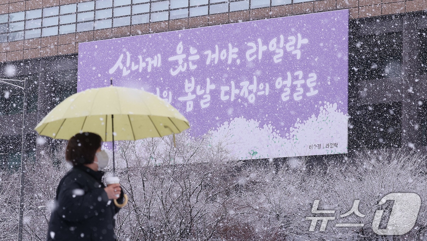 난데없는 3월 대설주의보가 발효된 18일 오전 서울 광화문광장에서 한 시민이 광화문 봄글판 앞으로 지나가고 있다. 2025.3.18/뉴스1 ⓒ News1 박지혜 기자