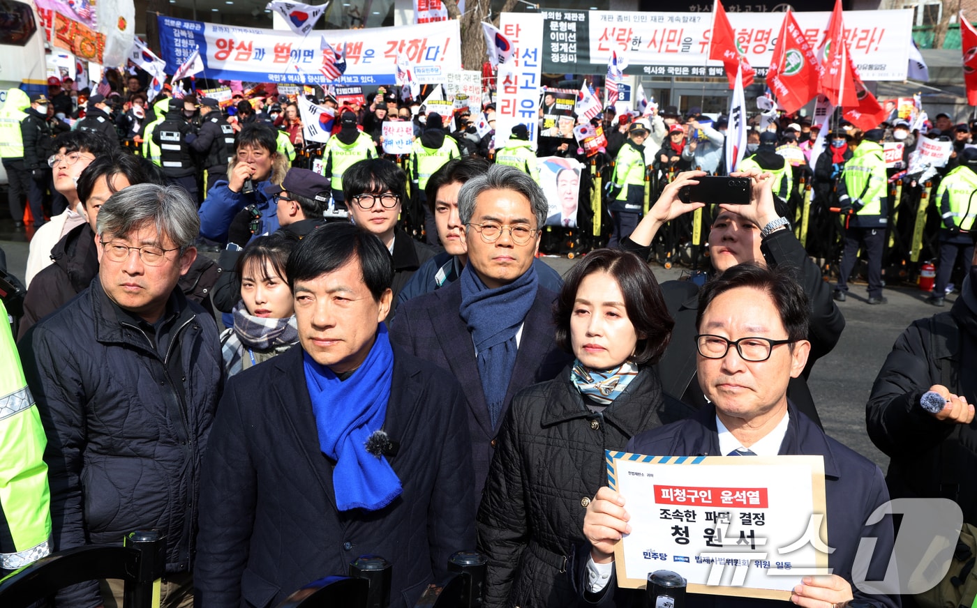 국회 법사위 야당 위원들이 18일 오후 서울 종로구 헌법재판소에서 피청구인 윤석열 파면 촉구 기자회견을 마치고 청원서를 접수하려 하고 있다. 한편 이날 기자회견 동안 뒤쪽 윤석열 대통령 지지자들이 야유를 보내고 있다. 2025.3.18/뉴스1 ⓒ News1 김명섭 기자