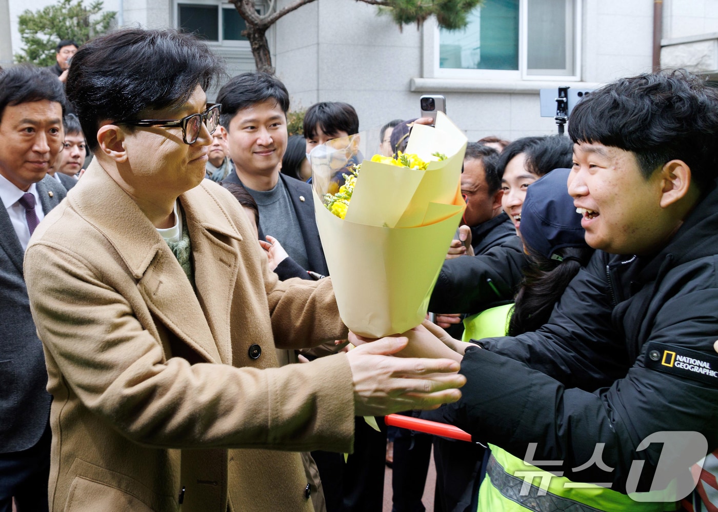 한동훈 국민의힘 전 대표가 2일 오후 서울 종로구 나온 씨어터에서 제2연평해전을 다룬 공연 &#39;바다는 비에 젖지 않는다&#39;를 관람하기 위해 이동하며 지지자들에게 꽃다발을 받고 있다. &#40;공동취재&#41; 2025.3.2/뉴스1 ⓒ News1 김명섭 기자
