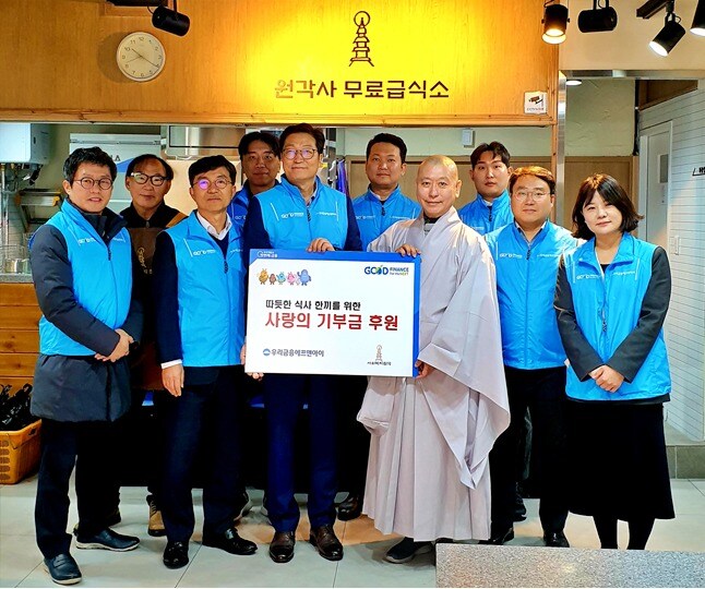 우리금융에프앤아이 김건호 대표이사(왼쪽에서 다섯번째), 전성찬 상무(왼쪽에서 세번째), 원각사 원경스님(왼쪽에서 일곱번째)이 기념촬영을 하고있다. (우리금융그룹 제공)